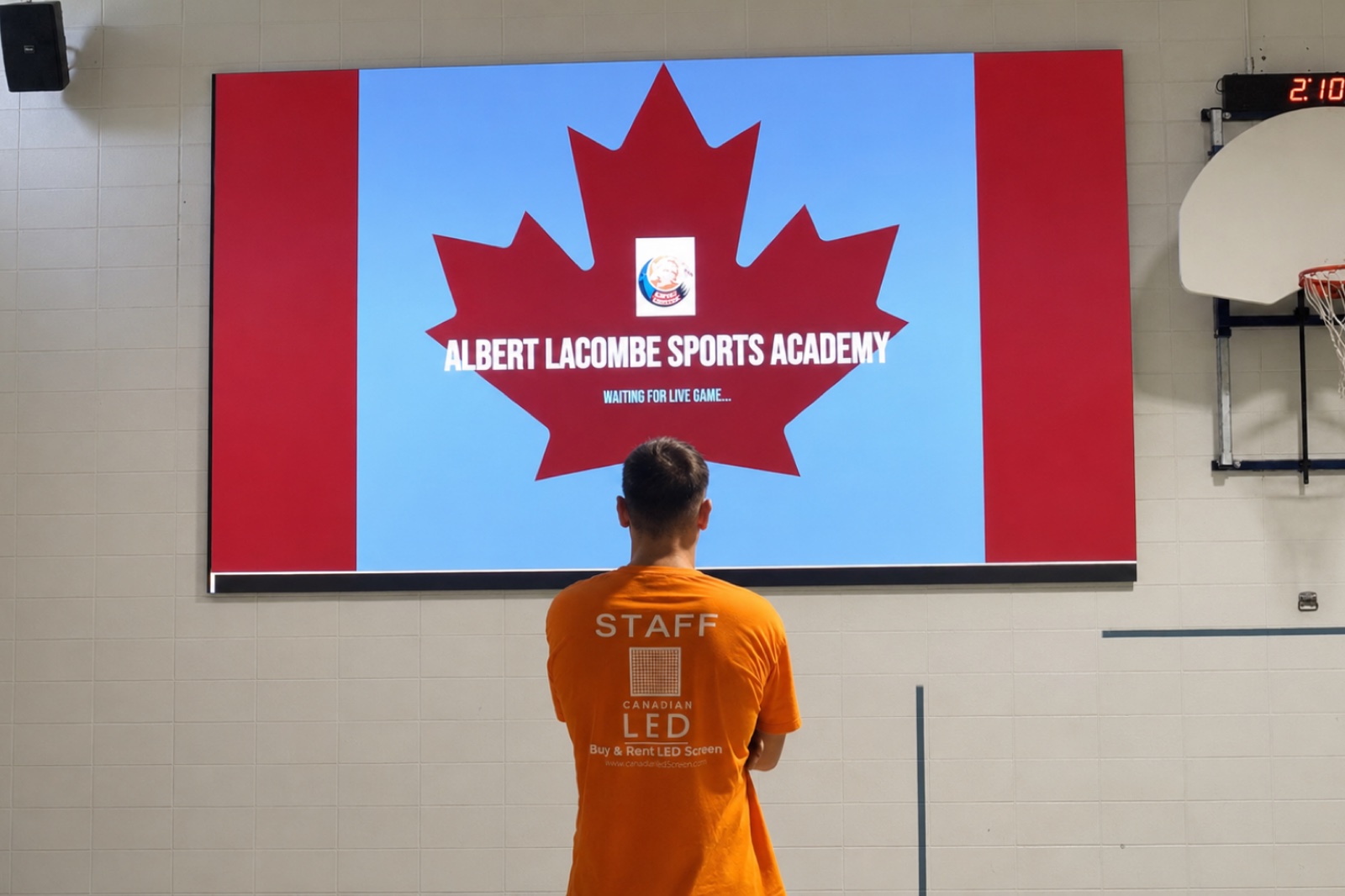 Canadian LED technician viewing the completed LED video wall at Albert Lacombe Sports Academy