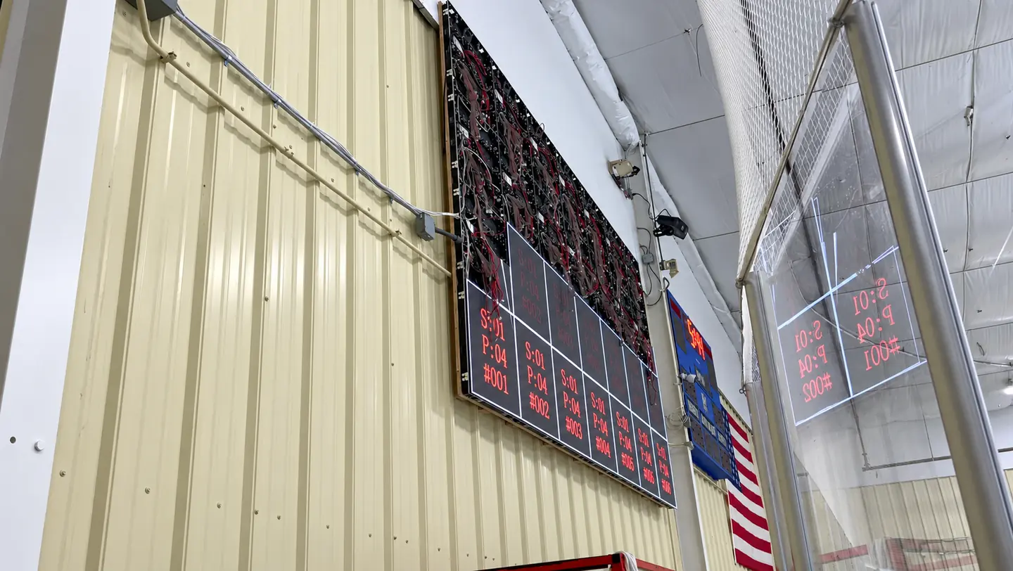 Partially assembled LED video wall showing exposed modules and cabling at Westchester Skating Academy